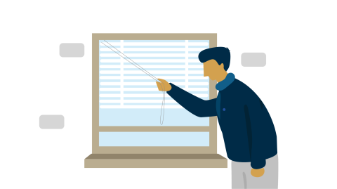 A man closing the blinds on a window.